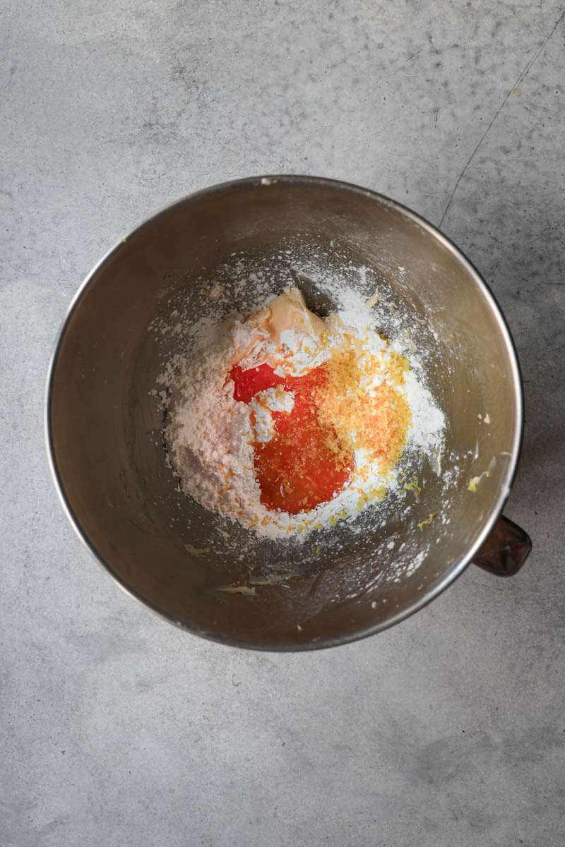 Manteca y azúcar impalpable más las yemas de huevo, la ralladura de limón, y los ingredientes secos en un bol para realizar la masa de los alfajores de maicena.
