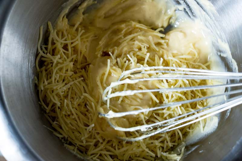 Mezclando el queso con la salsa blanca y las yemas