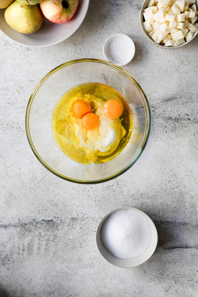 Plano aéreo de un bol de vidrio con los huevos, el aceite de oliva y el yogurt