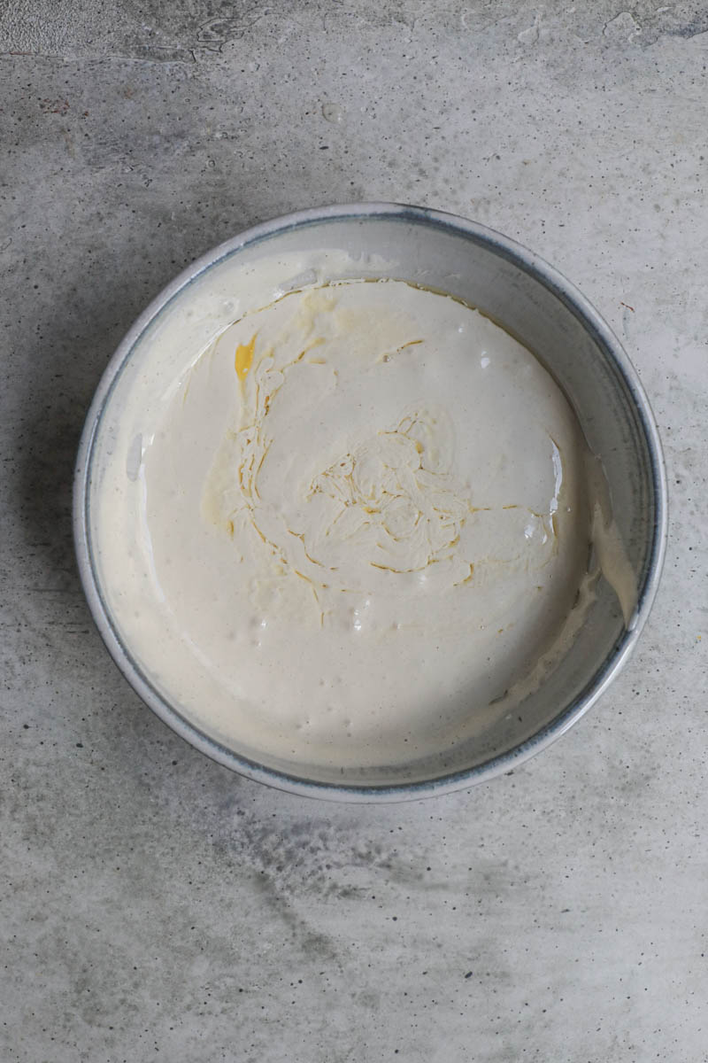 Melted butter and some of the almond cake batter mixed inside a small bowl.