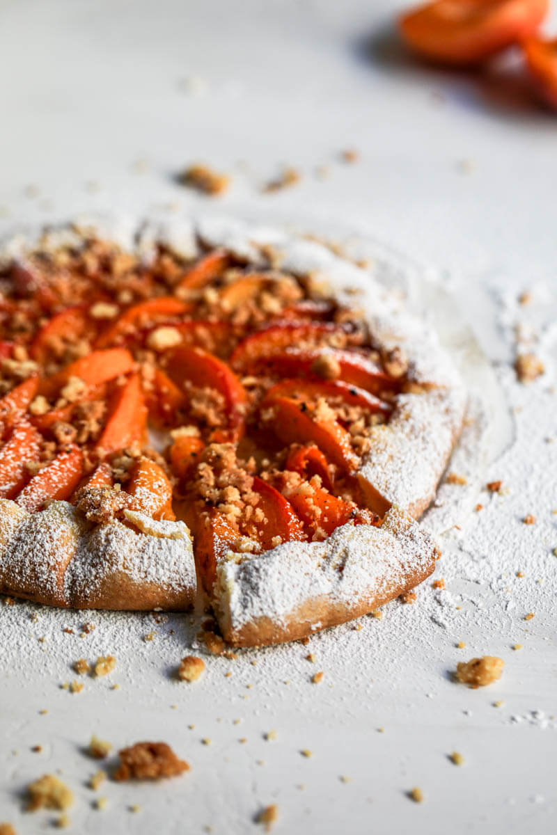 45° shot of the baked apricot tart with a sliced portion.