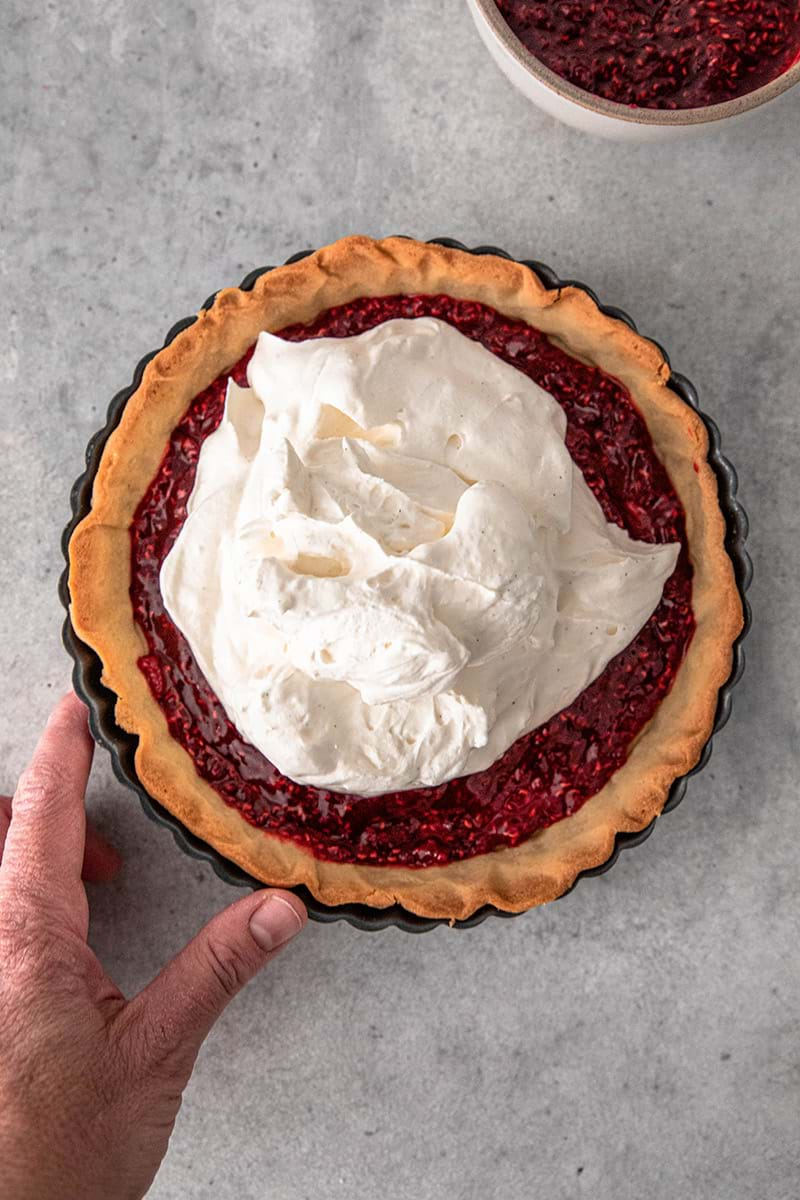 Overhead shot of the tart shell filled with raspberry jam topped with the vanilla mascarpone cream