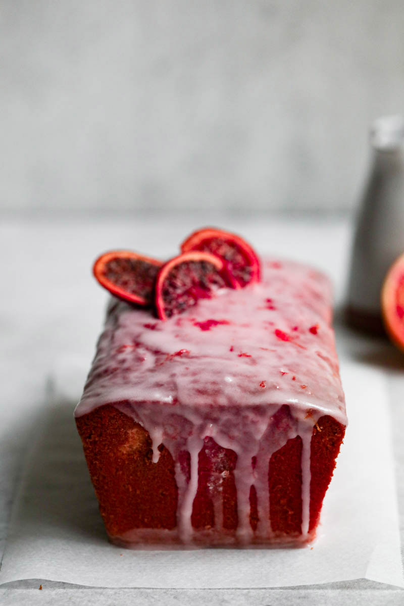 The whole glazed blood orange cake seen from the front.