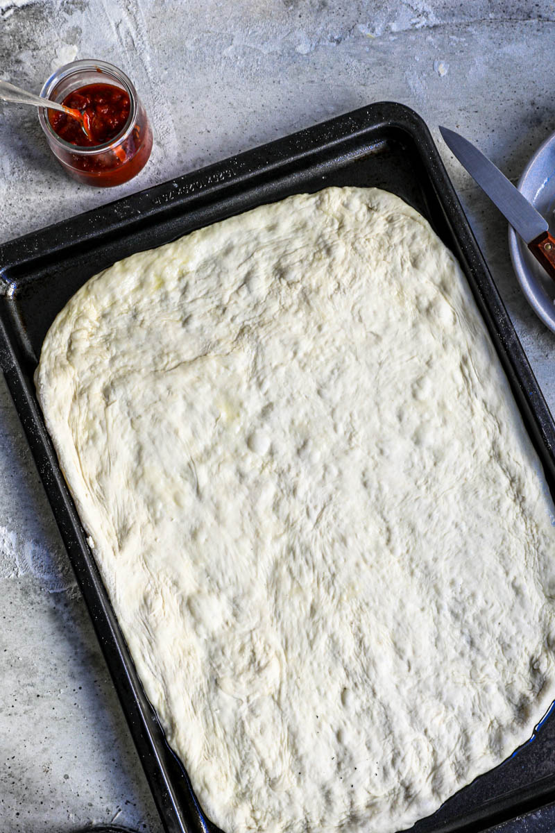 Overhead shot of the pizza dough on the baking tray