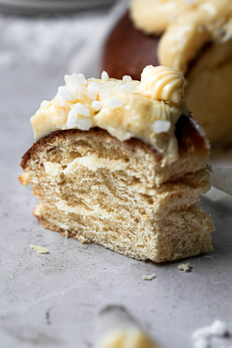 A slice of the Easter Bread with the whole bread blurry in the background.