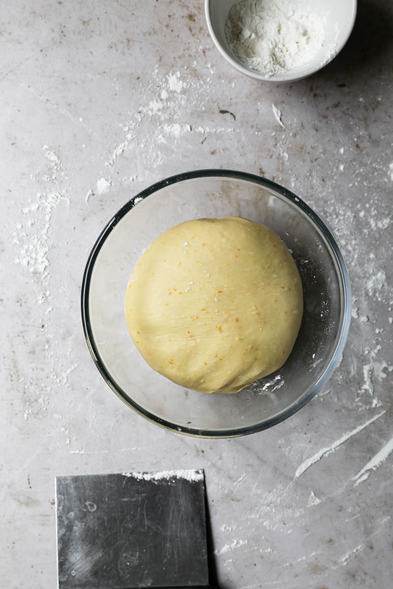 Easter bread dough placed inside a clean glass bowl ready to prove.