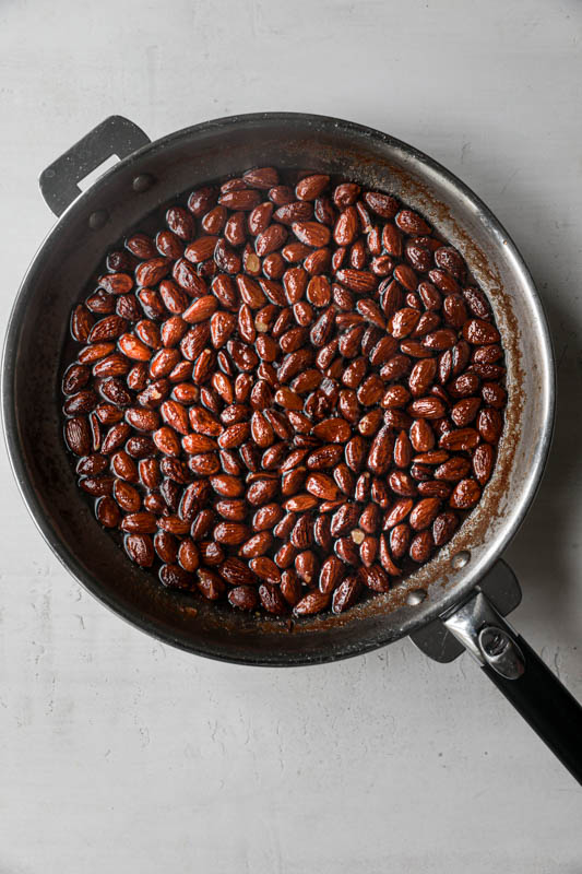 The almonds, the sugar and the water inside a pan.