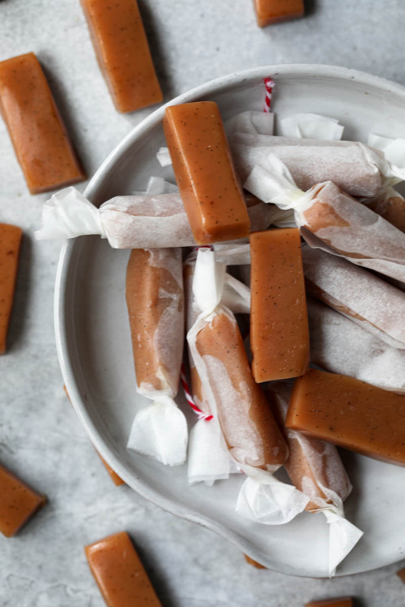 Wrapped caramel candies on a small plate