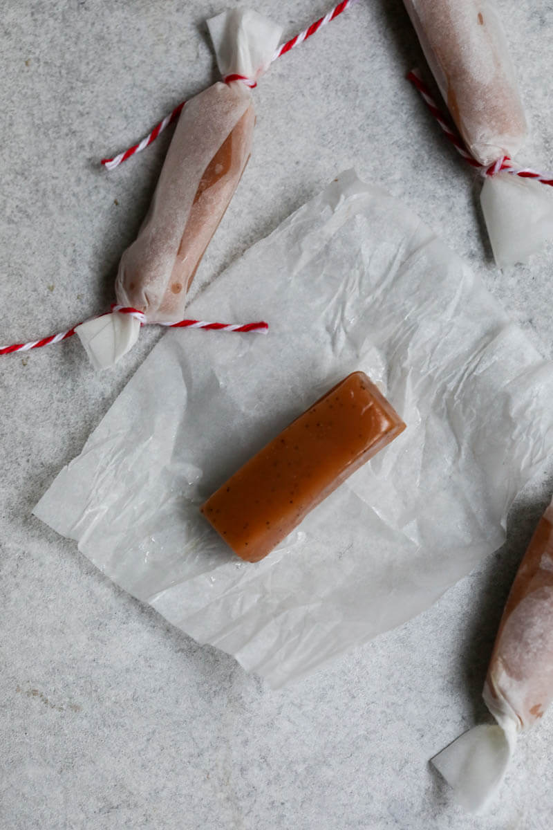 One caramel candy on a opened piece of parchment paper