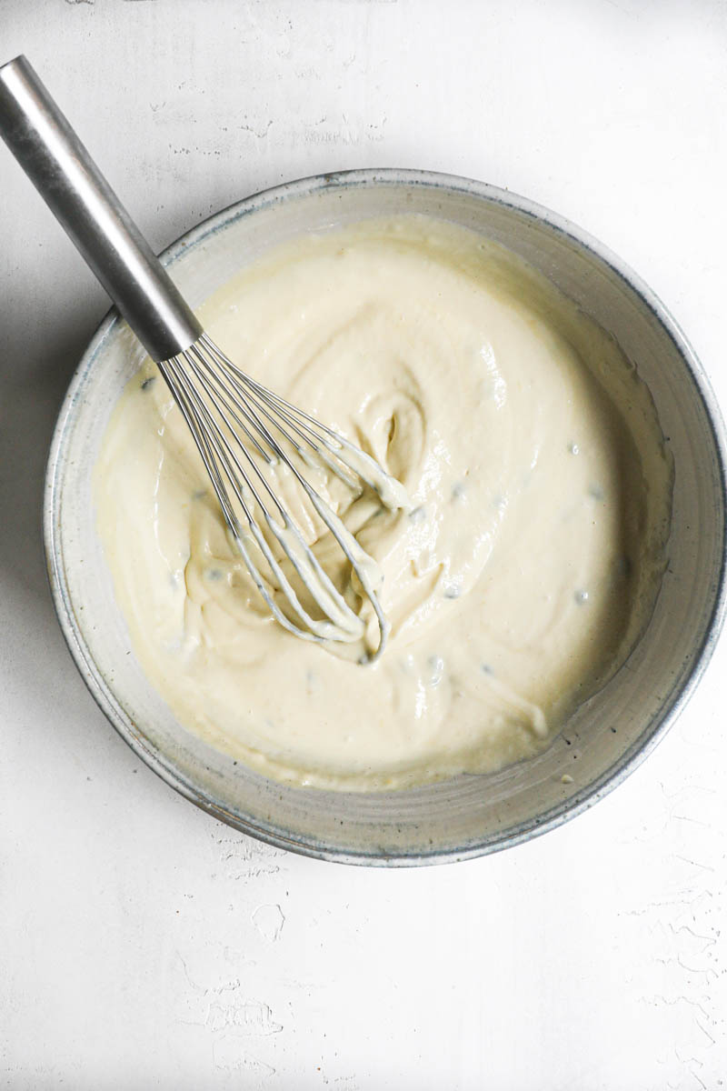 The passion fruit cheesecake batter ready inside a grey bowl.