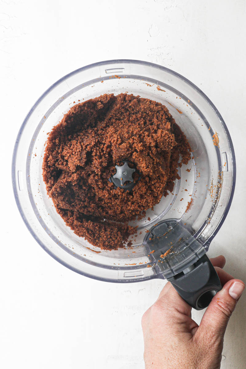 The biscoff cookie tart crust inside the food processor bowl.