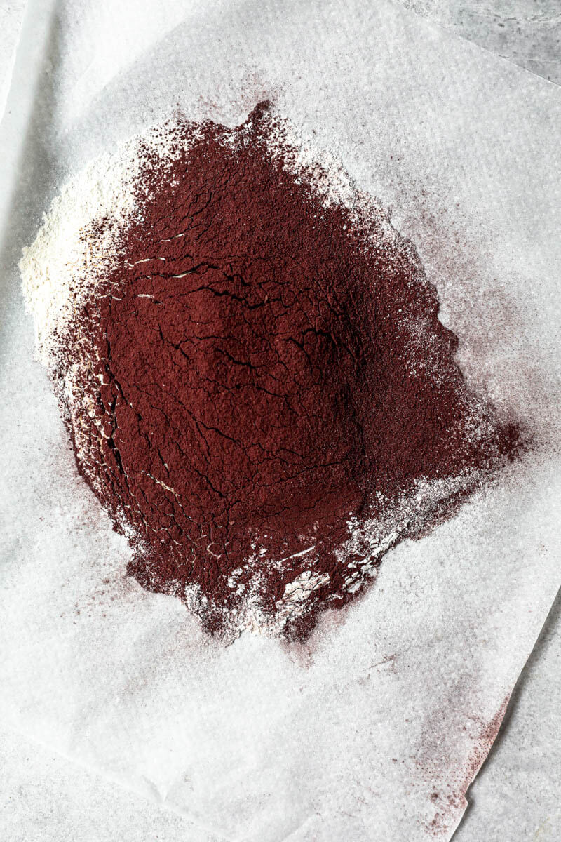 Overhead shot of the sifted flour and cacao on a piece of parchement paper