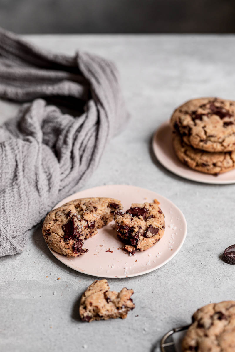 45° shot of one broken chocolate chunk cookie on a plate