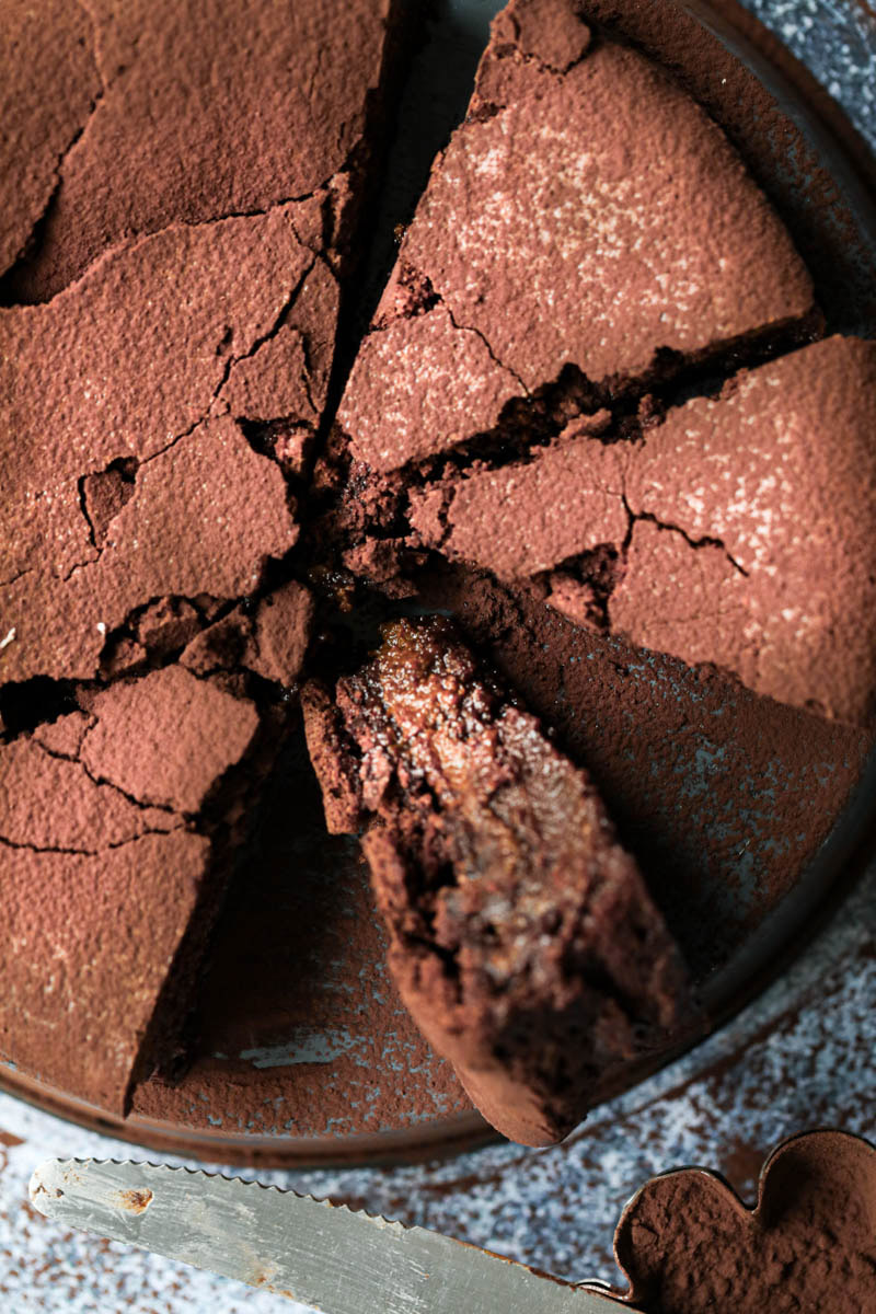 Closeup of the sliced chocolate fudge on a grey tray with a knife on the side.