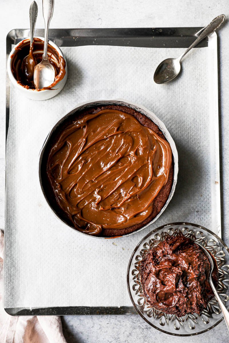 The chocolate fudge cake covered with a thin layer of dulce de leche on top of a baking tray.