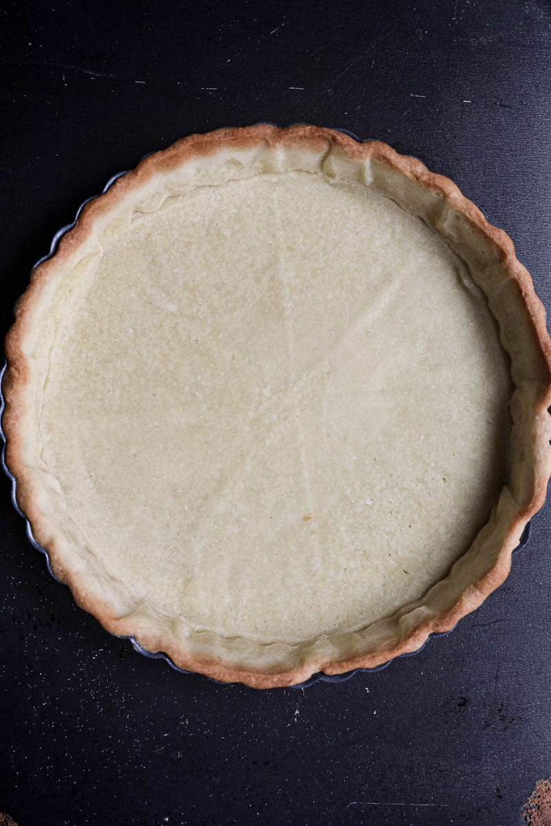 The pre baked shortbread crust inside the tart tin.