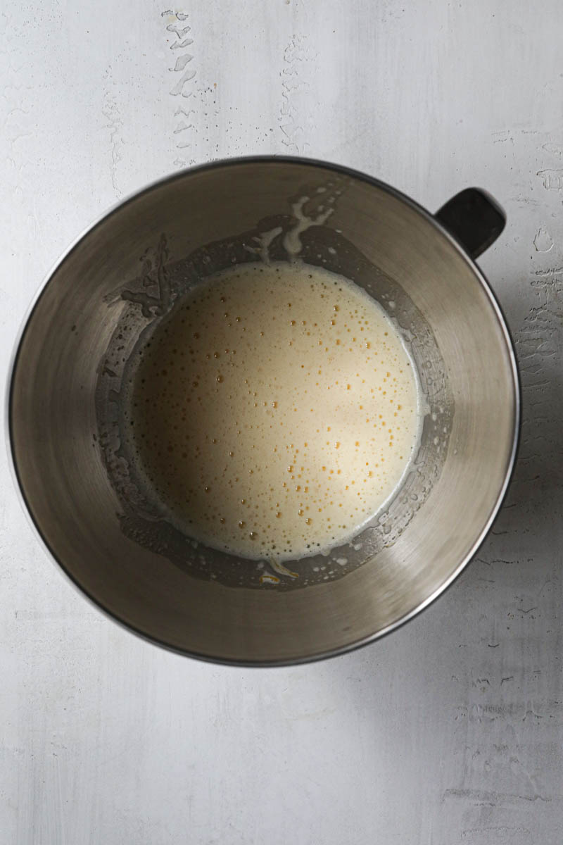 The beaten eggs, sugar and milk inside a mixing bowl.