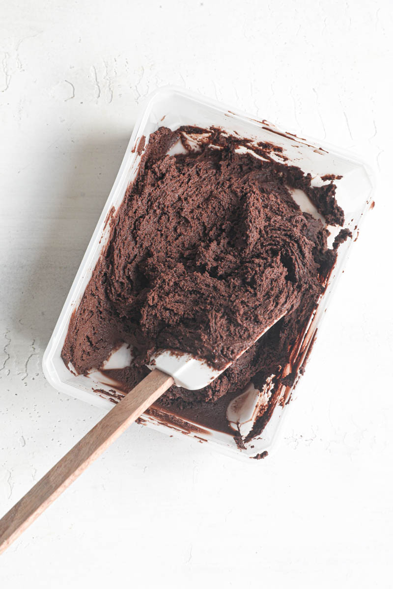 The smoothed out chocolate madeleine inside a plastic container after it has been chilled for 24 hours.