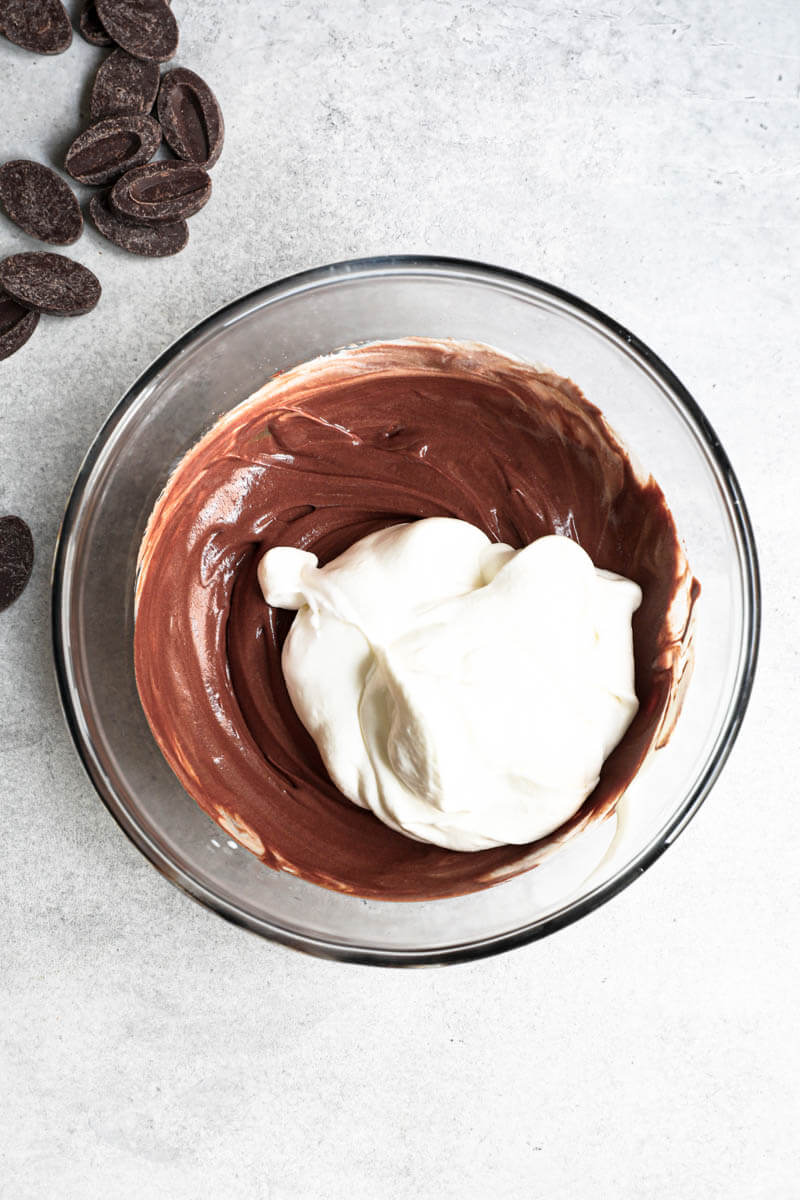 Overhead shot of a bowl holding the chocolate ganache and the whipped cream
