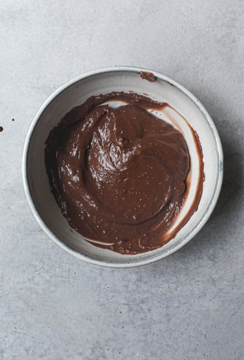 The chocolate pastry cream inside a grey a bowl.