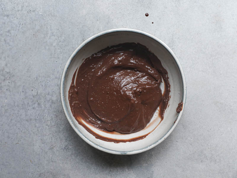 The chocolate pastry cream inside a grey a bowl.