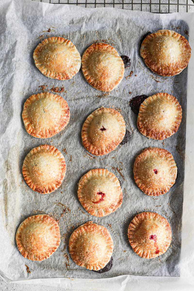 The baked chocolate raspberry mini hand pies placed over a wire rack.