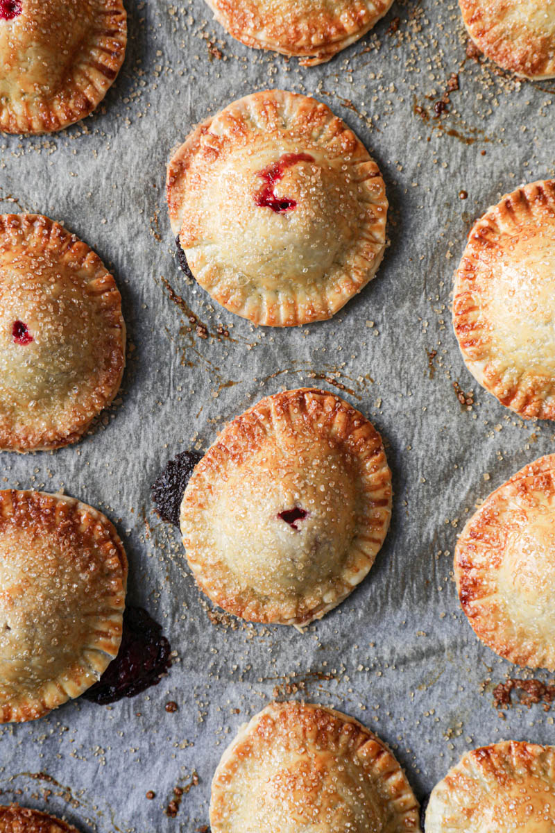 Closeup of the baked chocolate raspberry mini hand pies placed over a wire rack.