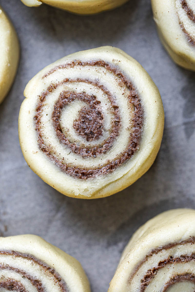 A closeup shot of 1 cinnamon roll before it has risen.