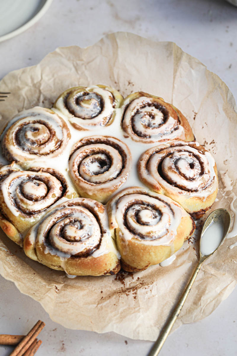 The whole small batch baked cinnamon rolls with a gold spoon on the side.
