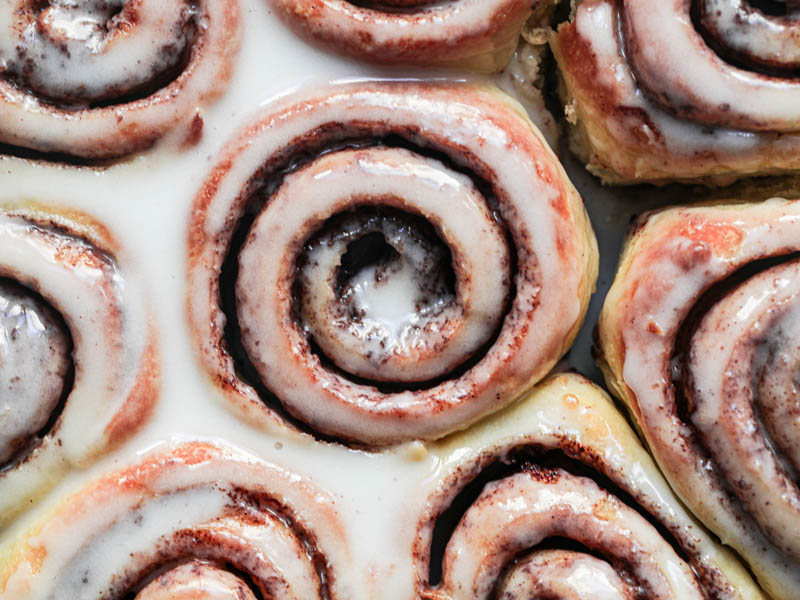 Closeup shot of the glazed brioche cinnamon rolls as seen from above.