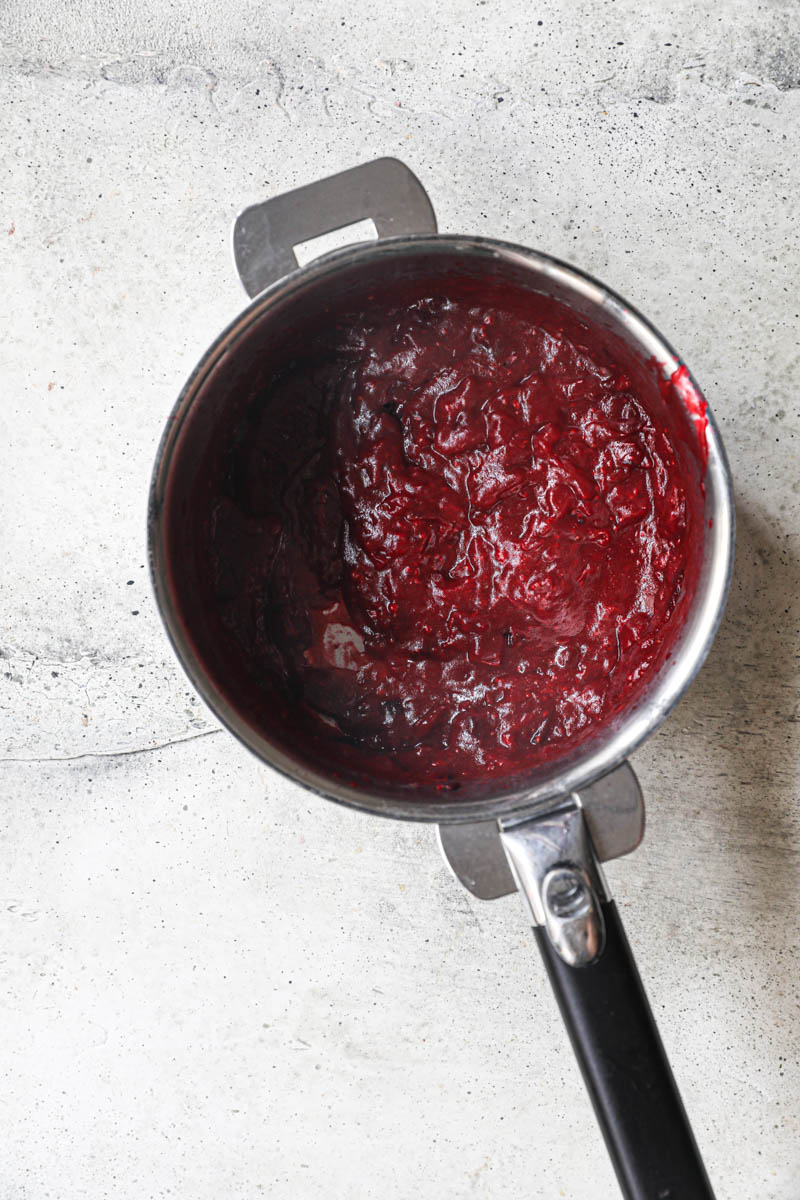 The cranberries and the orange juice pureed inside a pan.