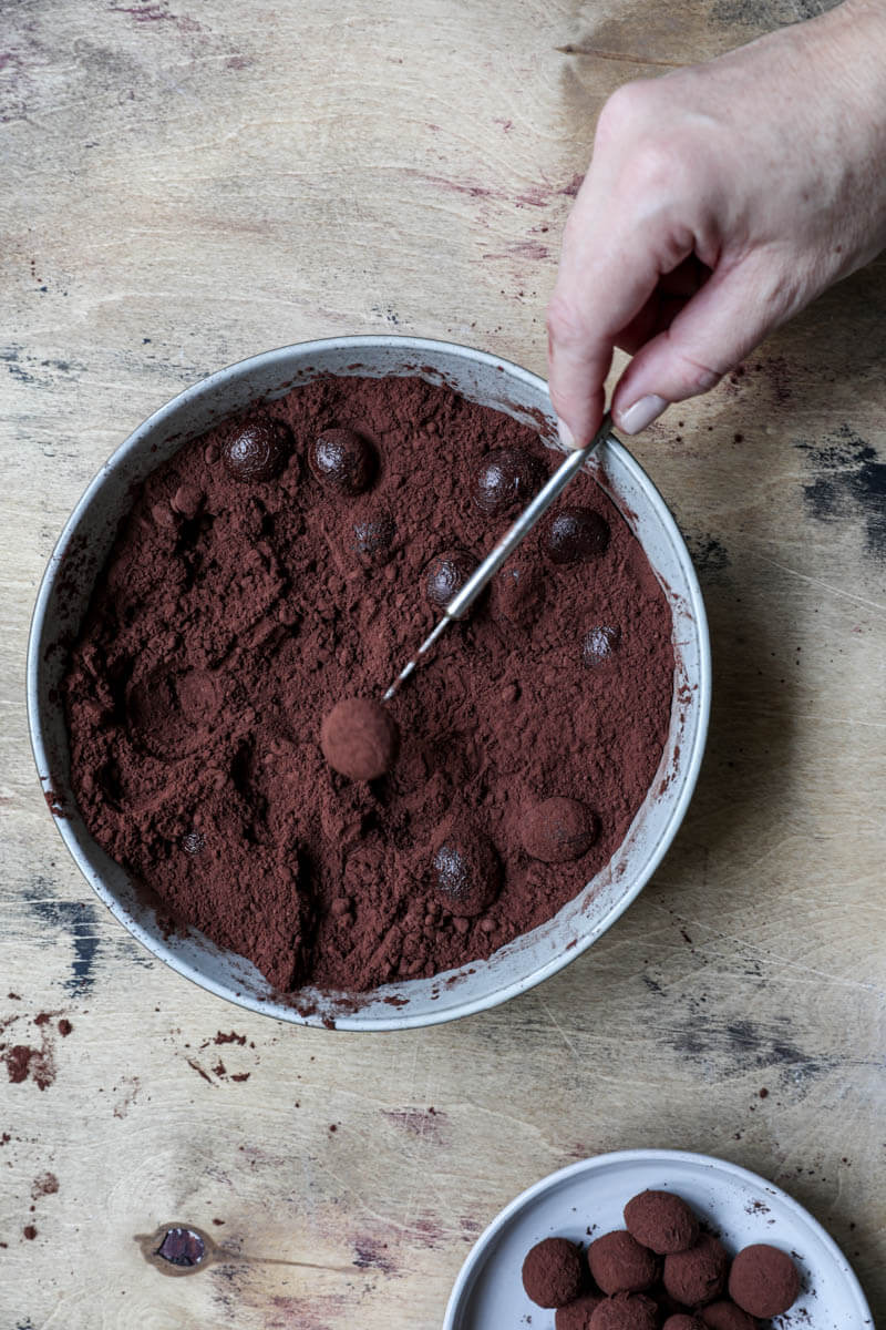 One hand removing a truffle with a mini fork