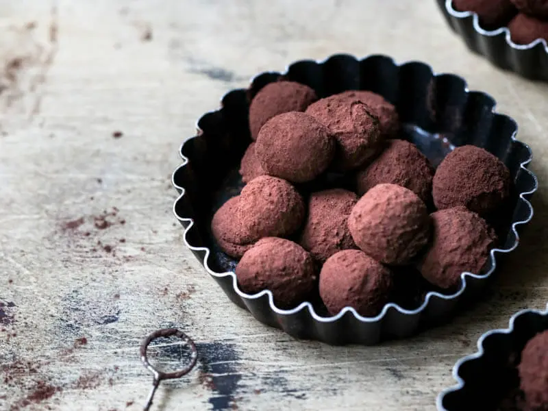 Dark chocolate truffles on a black tart tin