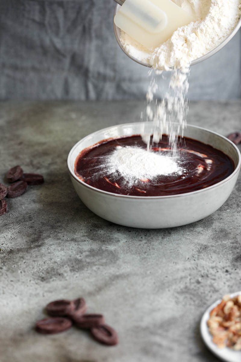 90° shot of flour being added into the brownie batter