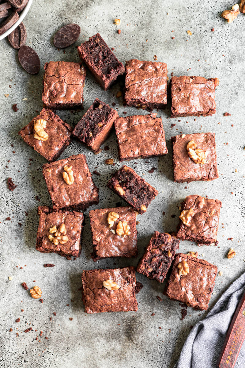Overhead shot of the cut brownies arranged in an irregular manner with a knife in the bottom right corner