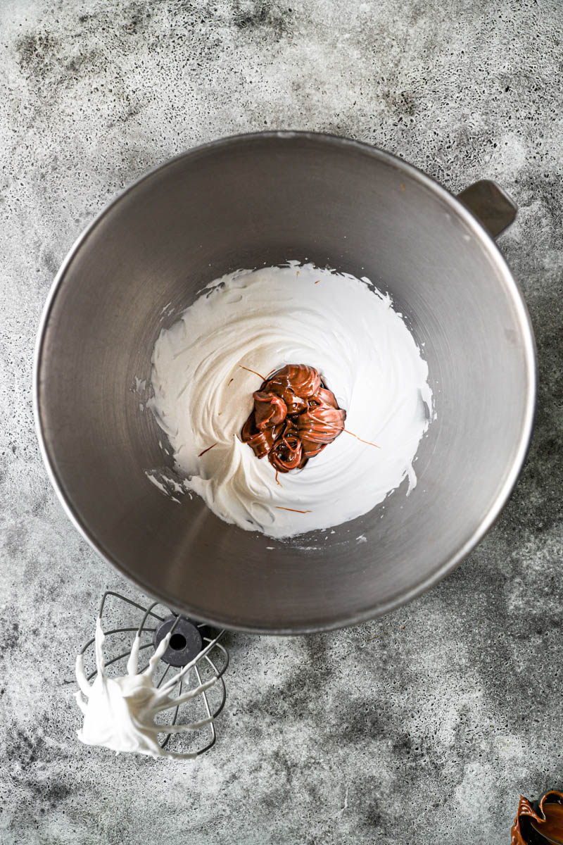 The whipped cream mixed with the dulce de leche in a bowl.
