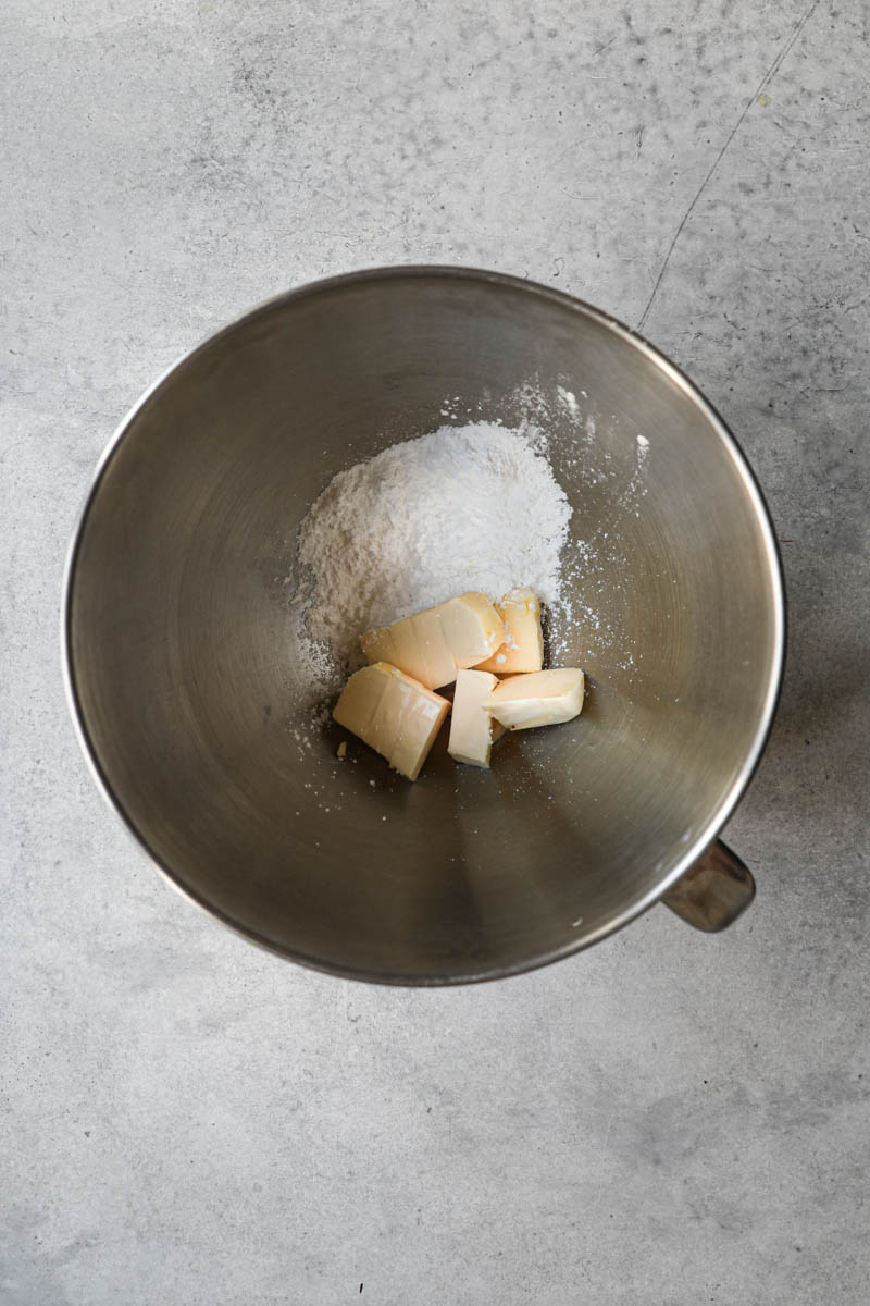 Butter and powdered sugar inside a mixing bowl, ready to start this afajores recipe.