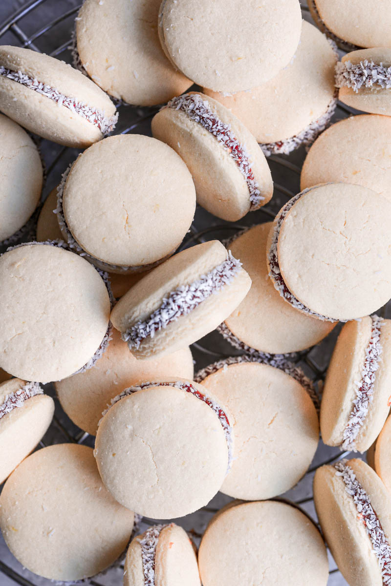 Many alfajores cookies arranged in a crazy manner, one on top of the other, as seen from above.