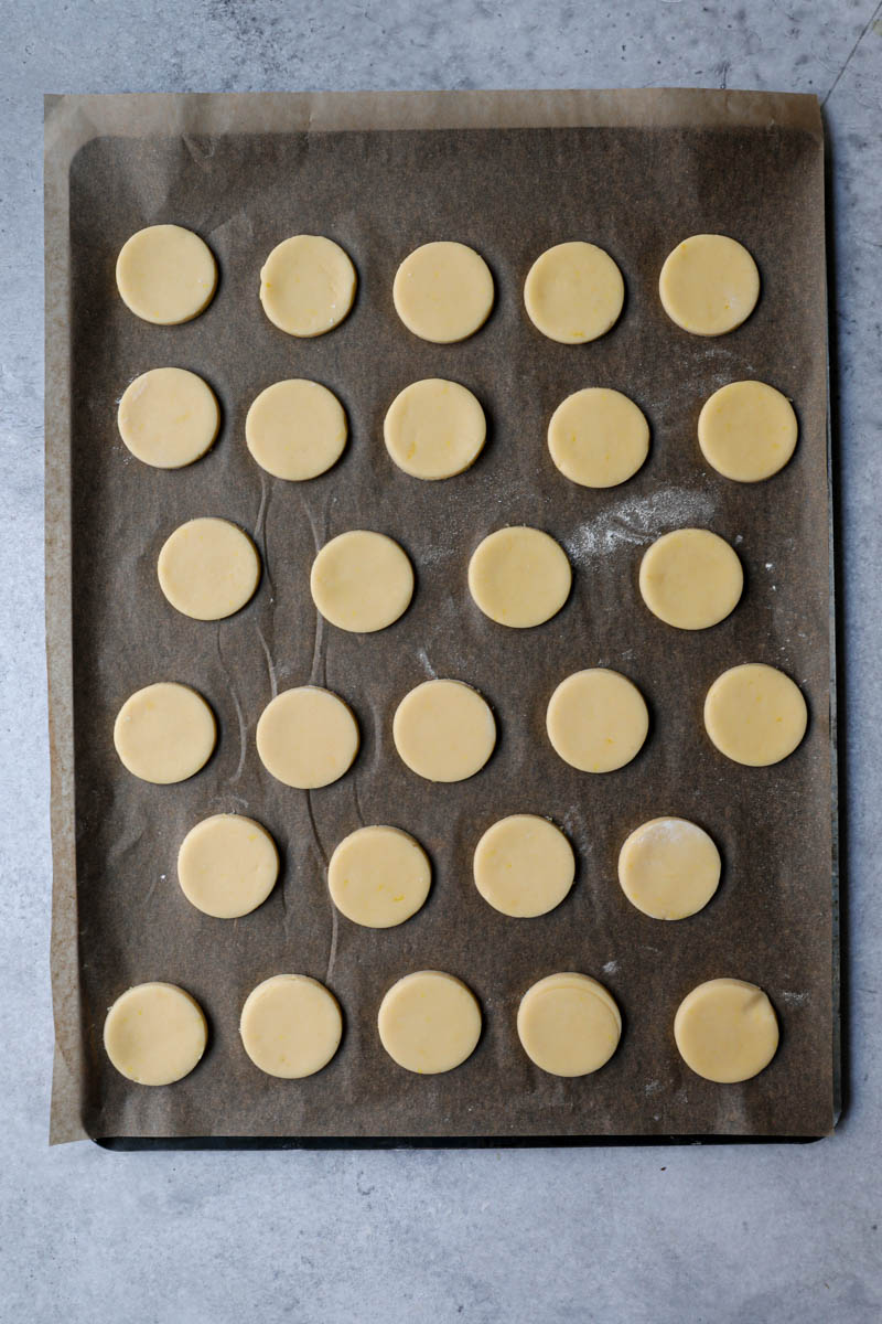 The alfajores cookies on a baking tray lined with parchment paper ready for the oven.