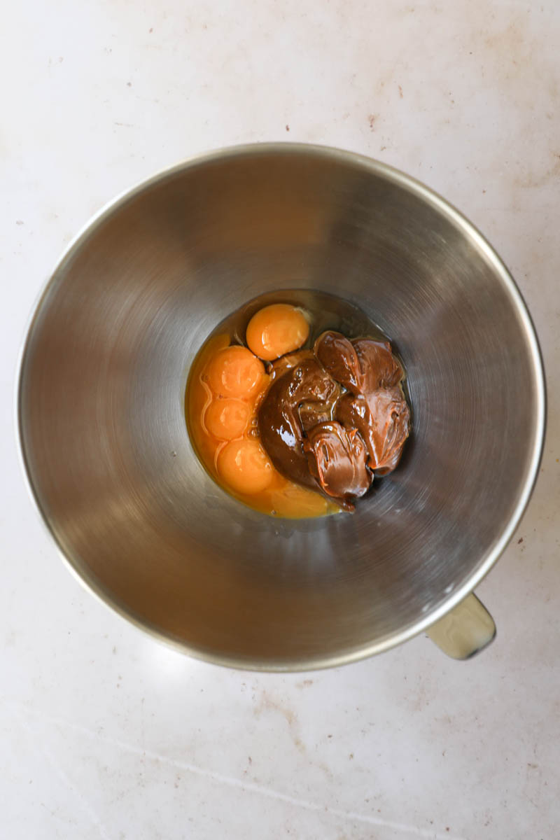Preparing the dulce de leche flan batter: a mixing bowl with the eggs and the dulce de leche.
