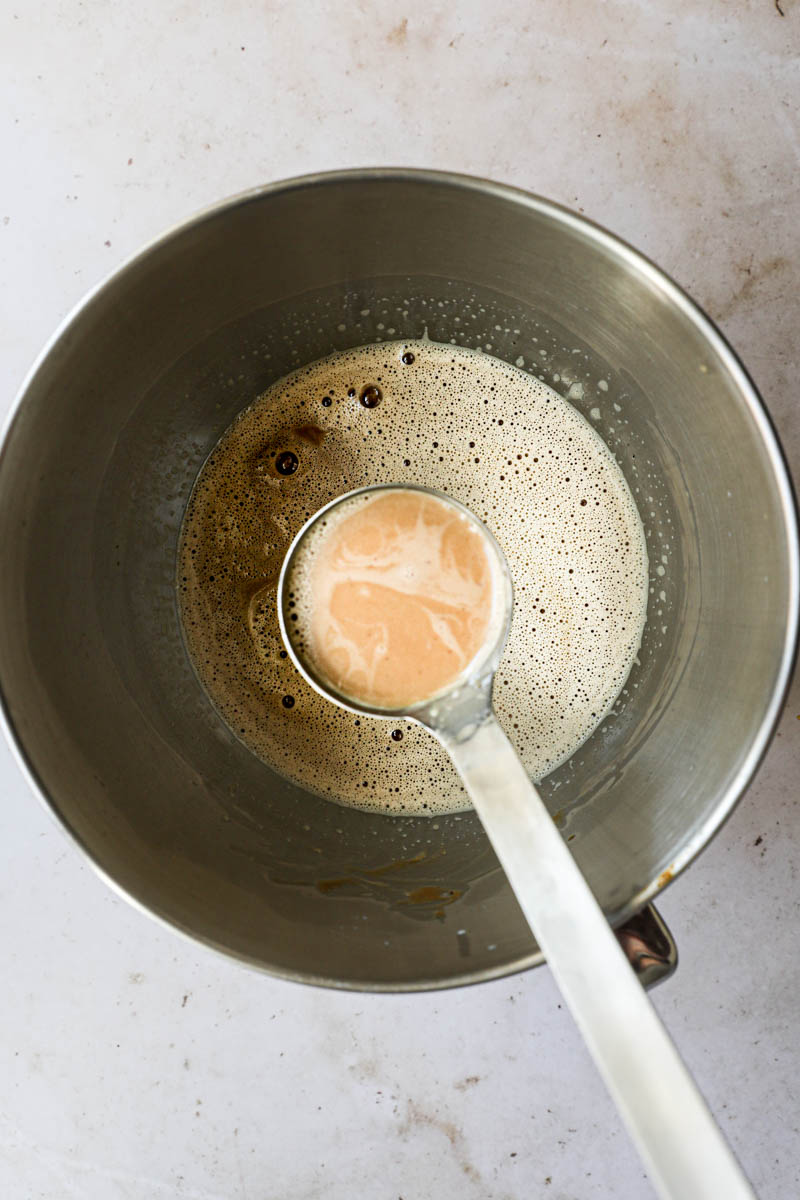 Preparing the dulce de leche flan batter:  the dulce de leche batter inside a mixing bowl with a ladle filled with some batter.