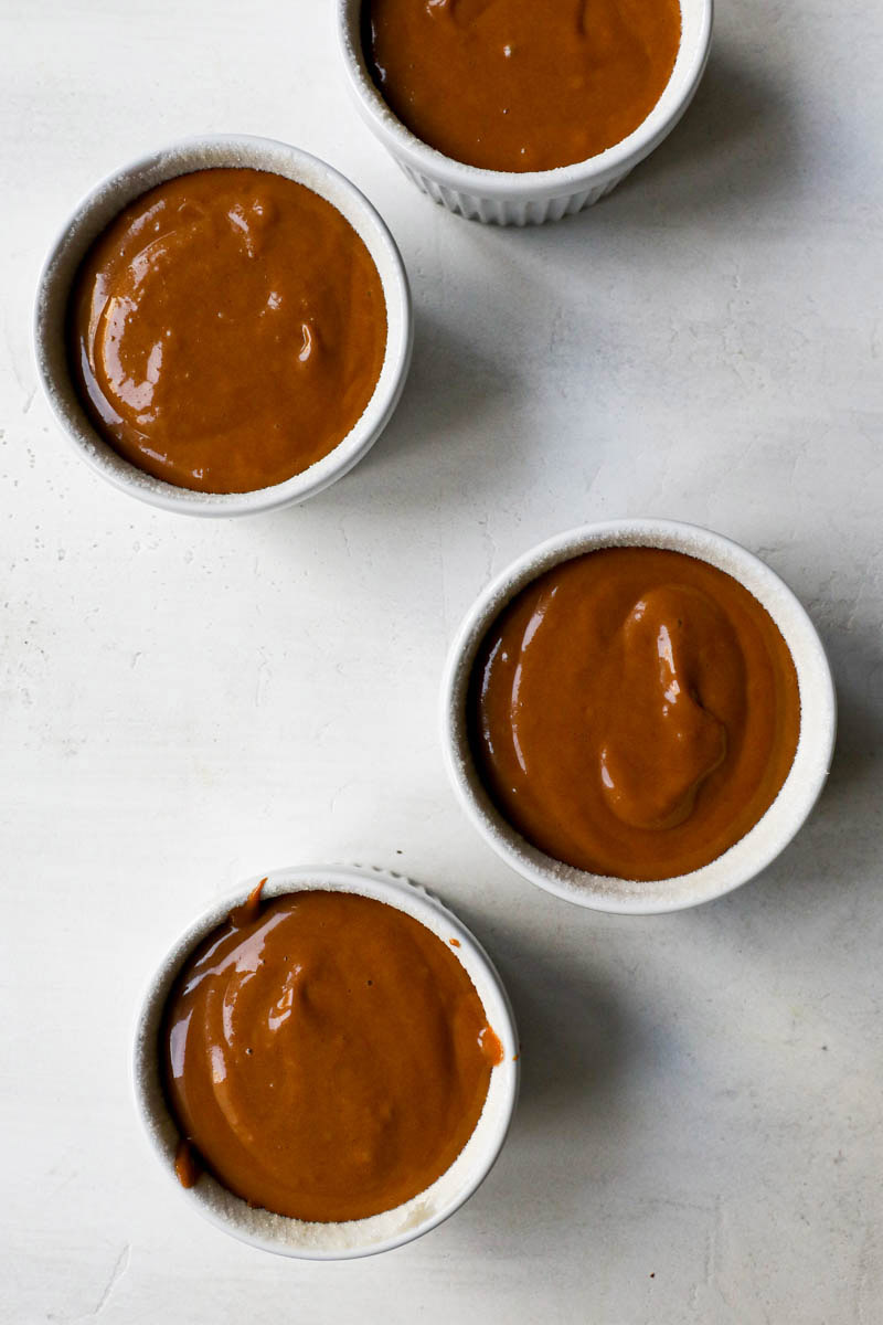 Mini souffle moulds filled with the dulce de leche cake batter.