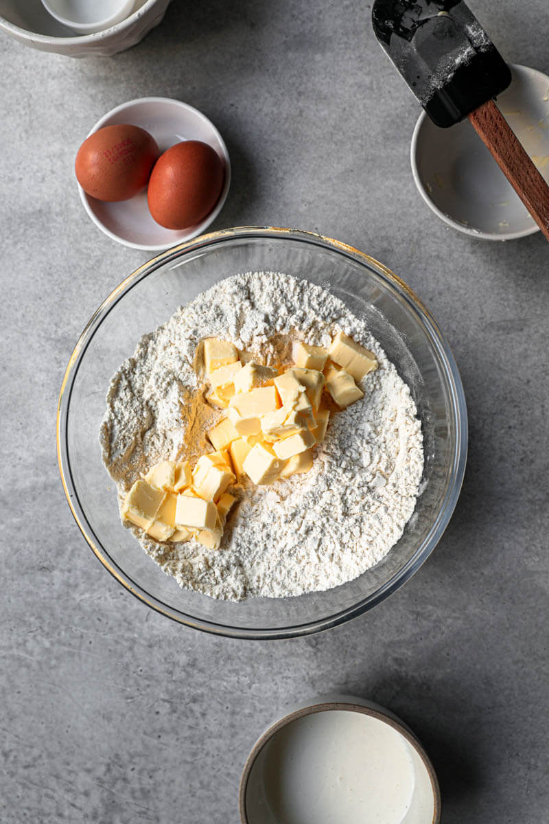 A bowl with dry ingredients and butter cut into cubes