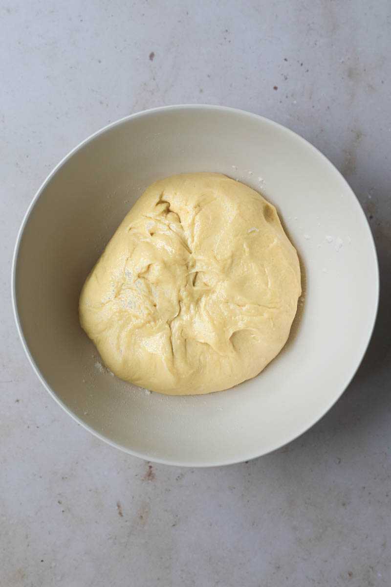 The French brioche bread dough ready inside a beige bowl ready for first rise.