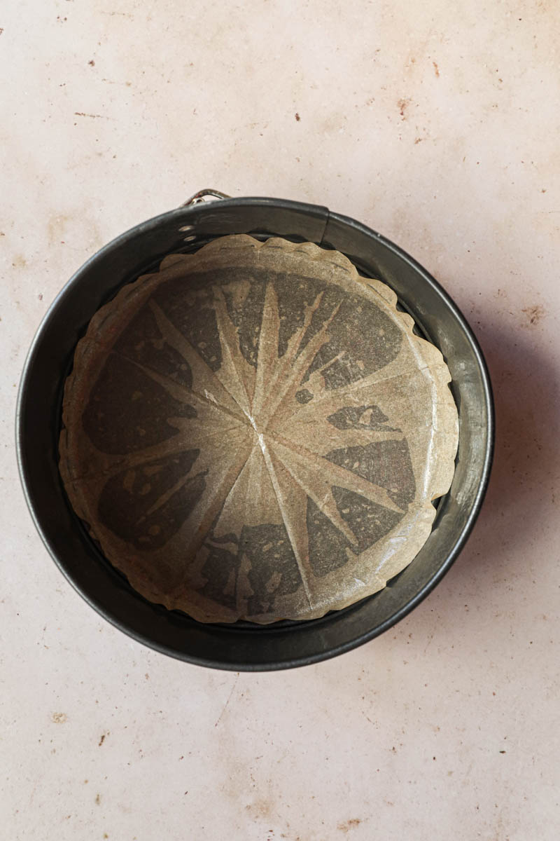 The springform cake pan lined with parchment paper.