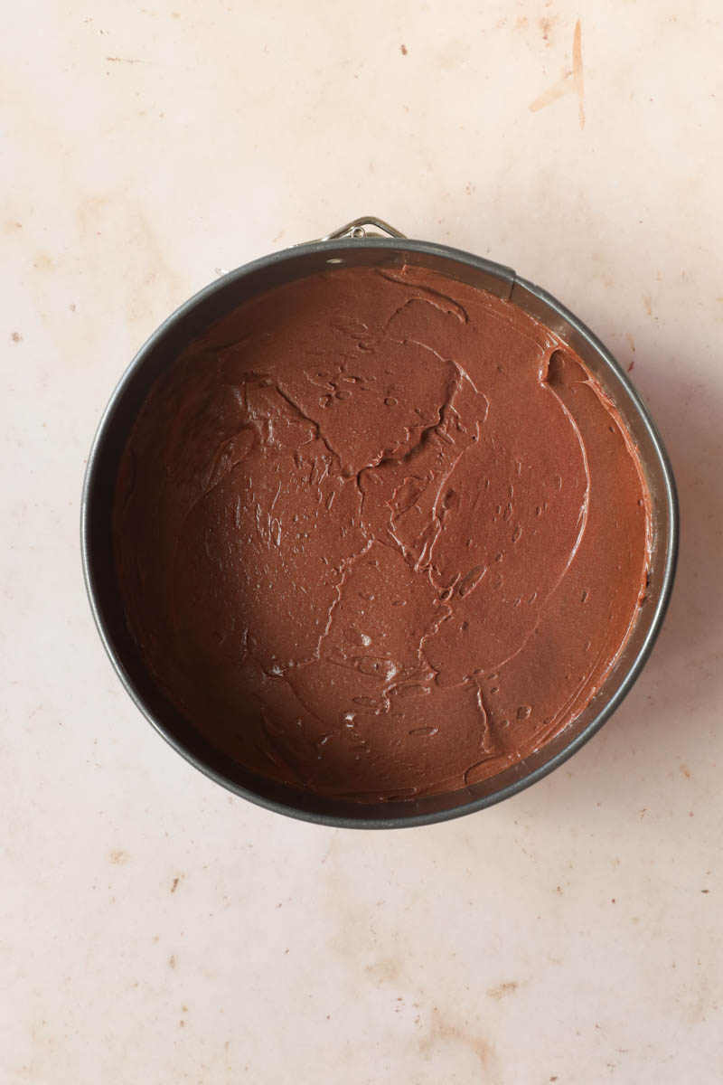 The French chocolate cake batter spread inside a springform cake pan.