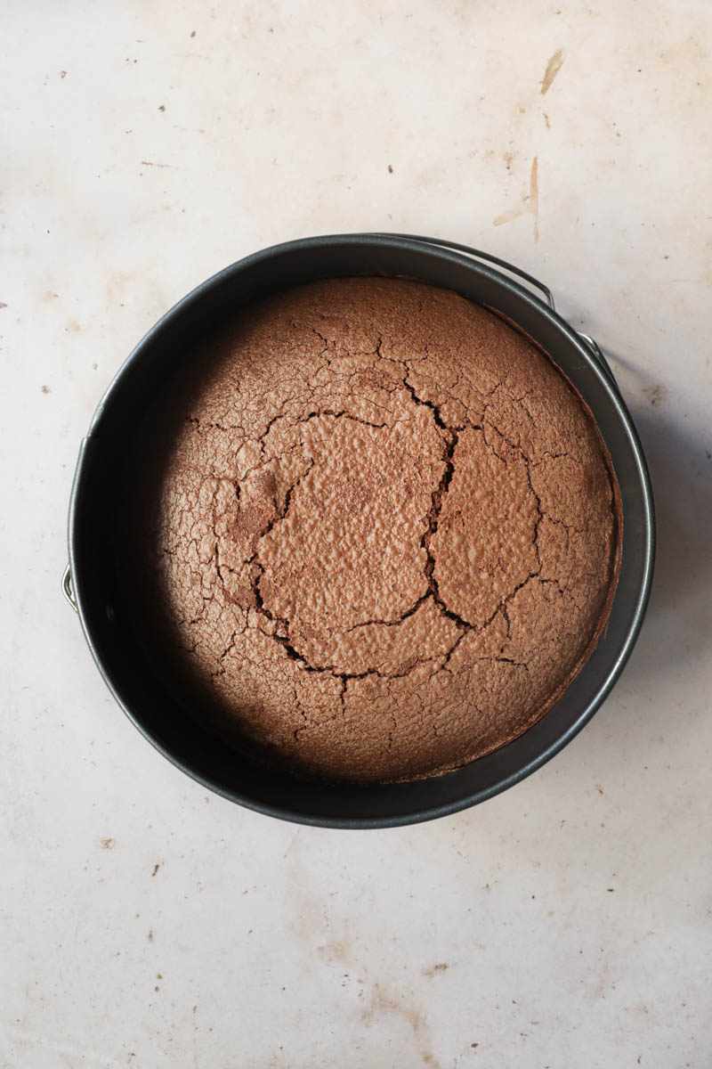 The baked French chocolate cake inside the baking pan on top of a wire rack.