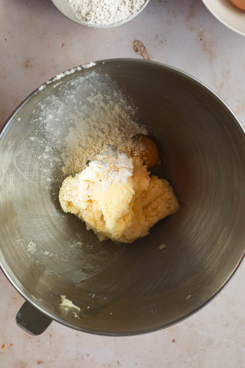 The eggs/sugar mixture plus some flower and an egg inside a mixing bowl.