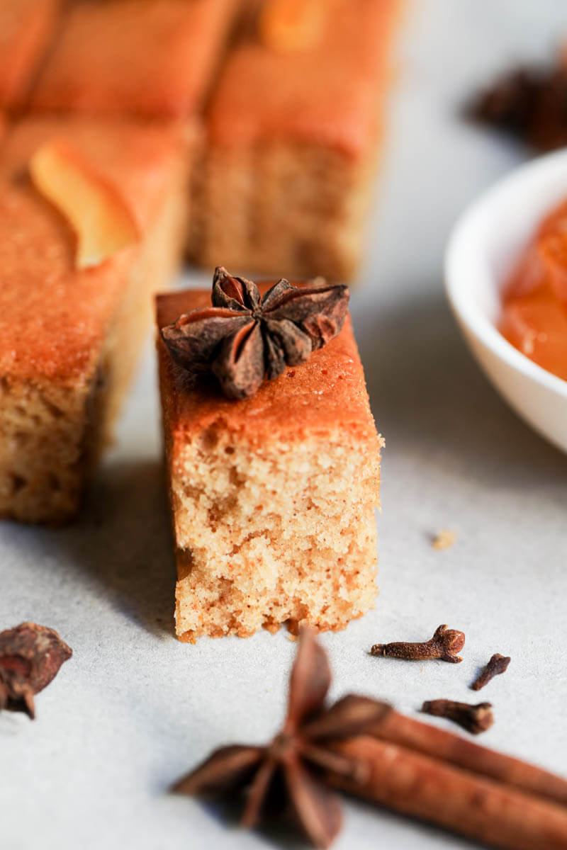 A mini pain d'épices sliced with the background blurry and a cinnamon stick in the right bottom corner