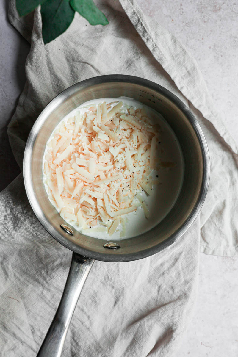 The parmesan and the cream inside a small pan.